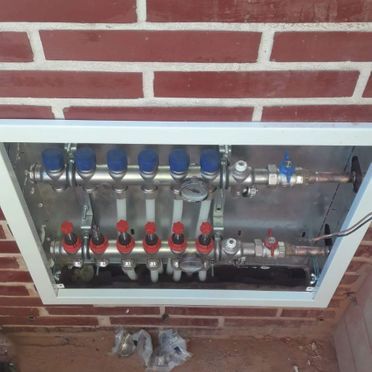 Una caja con un montón de tubos dentro está colocada sobre una pared de ladrillos.