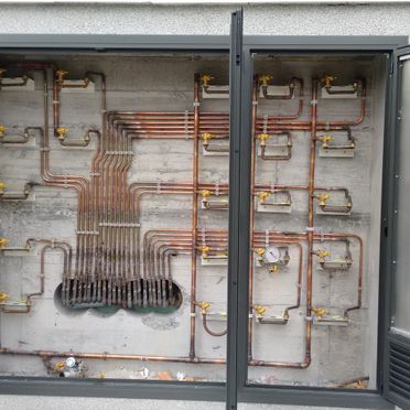 Una pared con un montón de tuberías saliendo de ella.