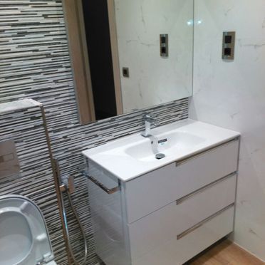 Un baño con lavabo, inodoro y espejo.