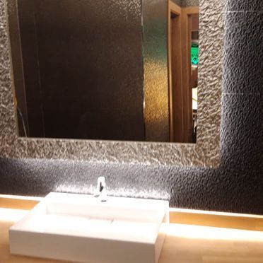 Un baño con lavabo y un espejo grande.