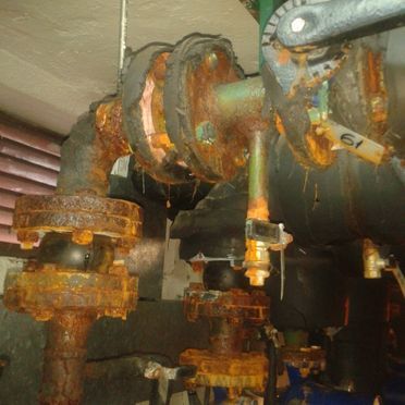 Un primer plano de una tubería oxidada en una habitación.