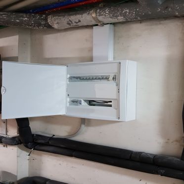 Una caja blanca está colgada en una pared con una puerta abierta.