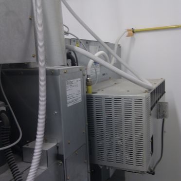 Una manguera blanca está conectada al costado de una máquina.