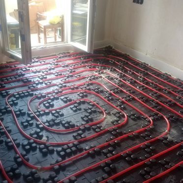 Una habitación con suelo radiante y puerta corrediza de cristal.