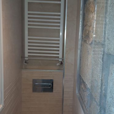 Un baño con toallero y un inodoro.