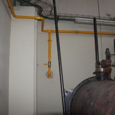 Una habitación con una tubería grande y una tubería amarilla.