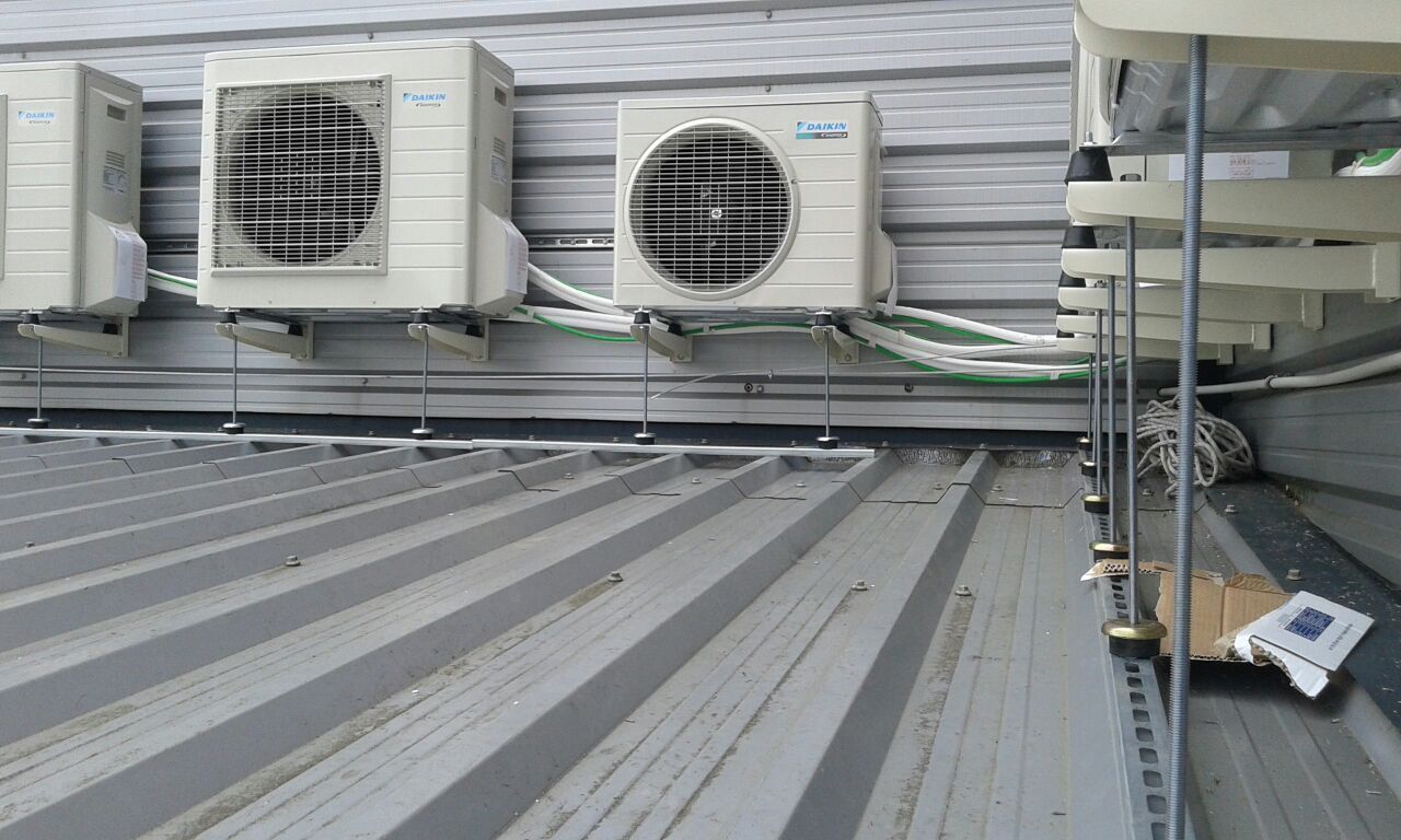 Hay muchos aparatos de aire acondicionado en el tejado de un edificio.