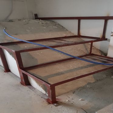 Una escalera de metal con una manguera azul unida a ella.