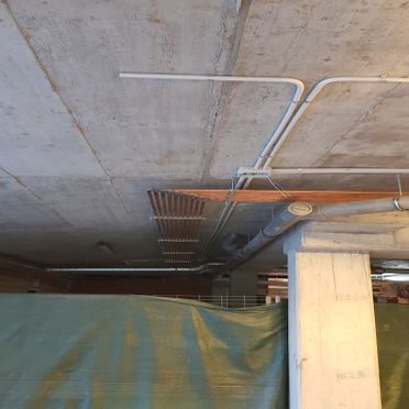 Hay muchas tuberías colgando del techo de un edificio.