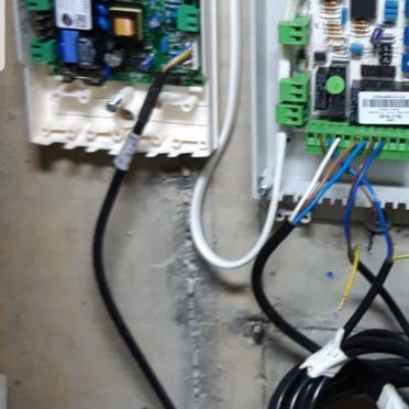 Un montón de cables están conectados a una caja en una pared.