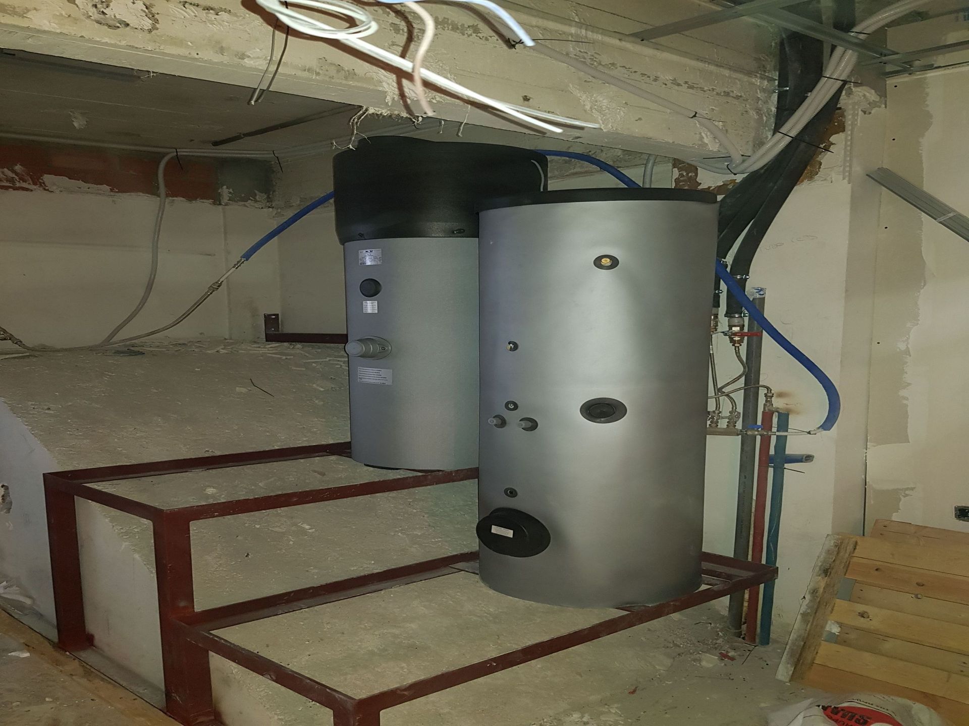 Hay dos calentadores de agua encima de las escaleras de una habitación.