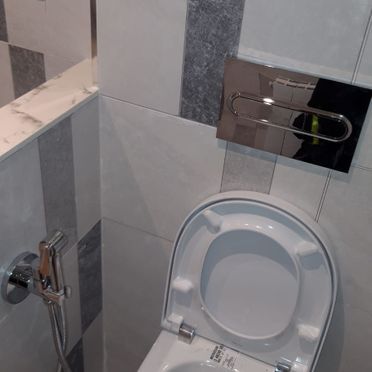 Un inodoro en un baño con un bidé adjunto.