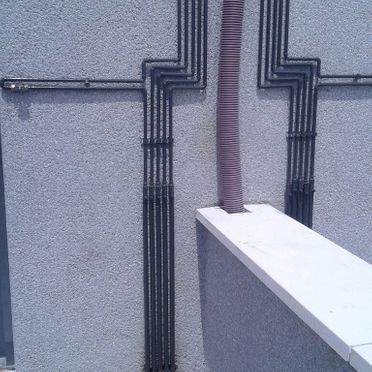 Una pared con un montón de tuberías sobre ella.