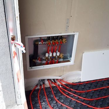 Una caja de la que salen tubos rojos está en una habitación.