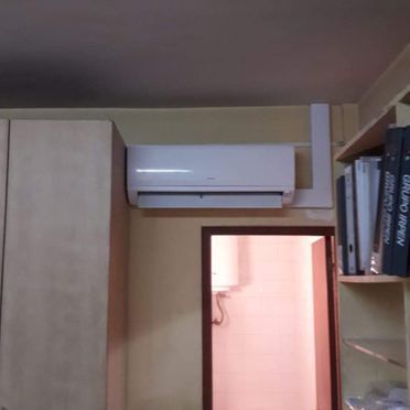 Un acondicionador de aire blanco cuelga del techo de una habitación.