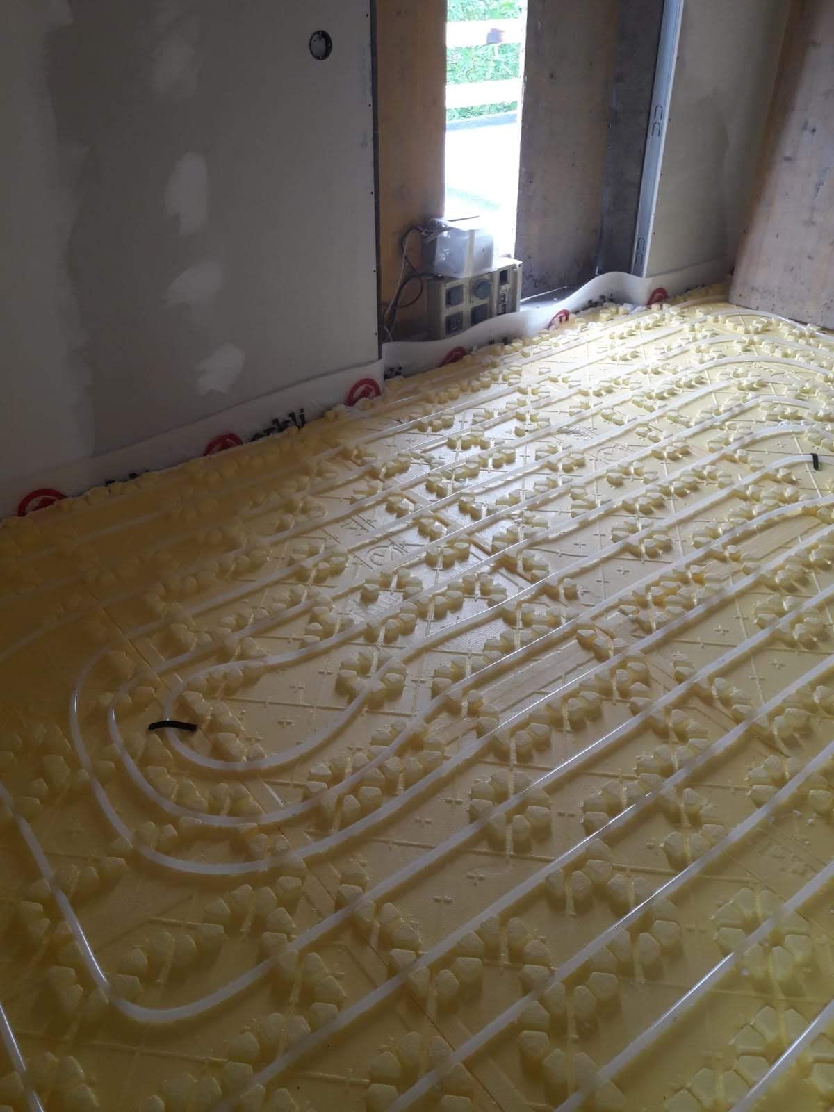 Una habitación con suelo amarillo y tuberías blancas.