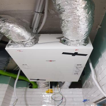 Un acondicionador de aire blanco cuelga del techo de una habitación.