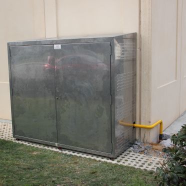 Un gabinete de acero inoxidable se encuentra en el costado de un edificio.