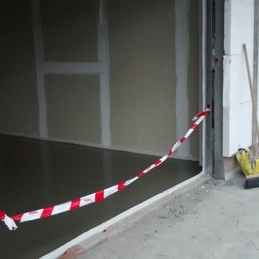 Una cinta roja y blanca cuelga de la puerta de un garaje.