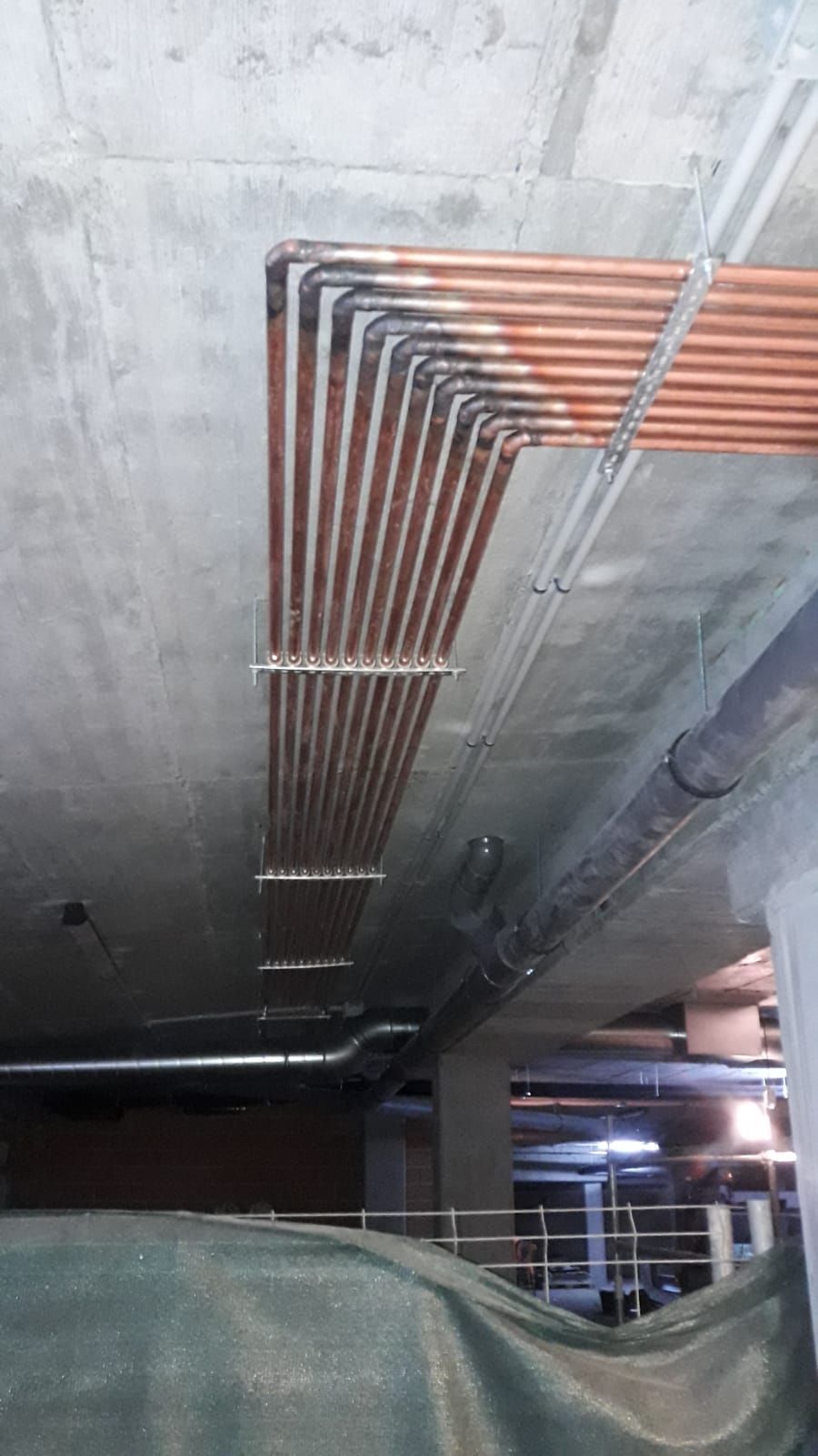 Un montón de tuberías cuelgan del techo de un edificio.