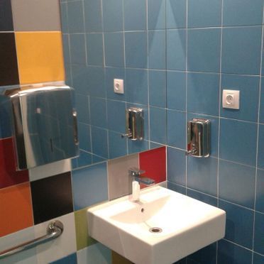 Un baño con azulejos azules y un lavabo.