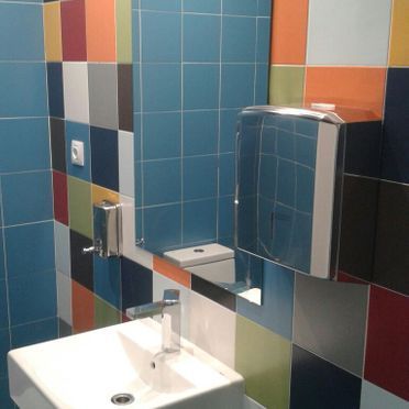Un baño con azulejos de colores y un lavabo.