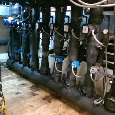 Una fila de tubos negros con válvulas azules.