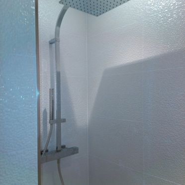 Hay un cabezal de ducha en la esquina del baño.