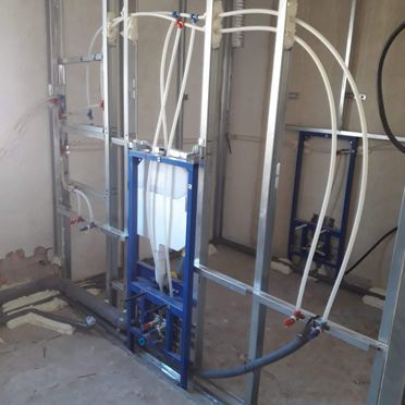 Un baño en construcción con un inodoro montado en la pared.