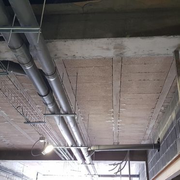 Un montón de tuberías cuelgan del techo de un edificio.