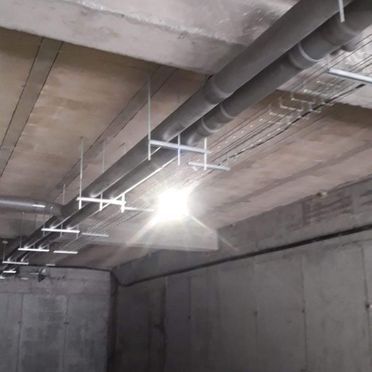 Una habitación con muchas tuberías colgando del techo.