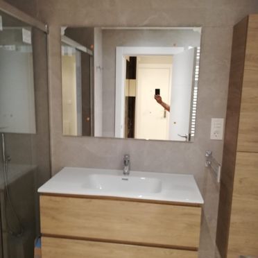 Un baño con lavabo y un espejo grande.