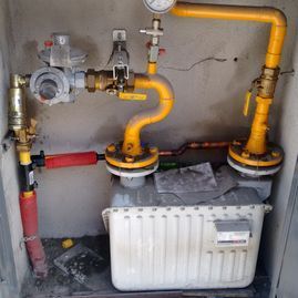 Un medidor de gas está conectado a una tubería de gas en una caja.