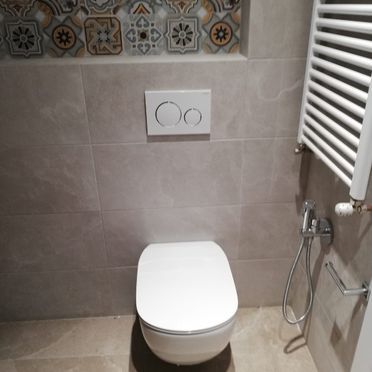 Un baño con inodoro y toallero.