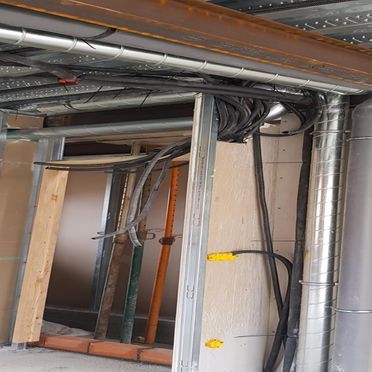 Un montón de cables cuelgan del techo de un edificio en construcción.