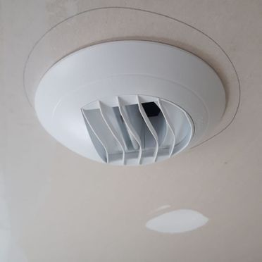 Un detector de humo blanco está montado en el techo de una habitación.