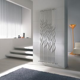 Una sala de estar con un radiador de acero inoxidable en la pared.