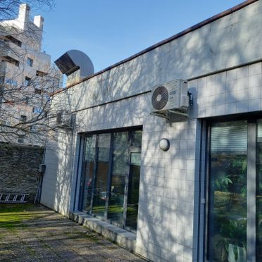 Un edificio con muchas ventanas y aparatos de aire acondicionado en los laterales.