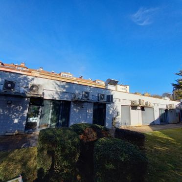 Un gran edificio blanco con muchos aparatos de aire acondicionado en el costado.