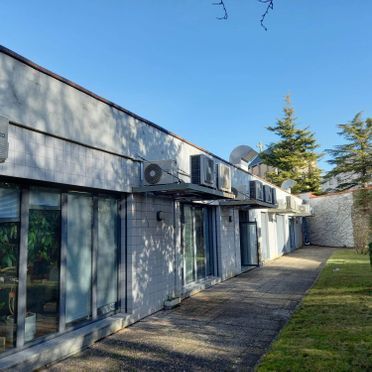 Un edificio grande con muchas ventanas y aparatos de aire acondicionado en los laterales.