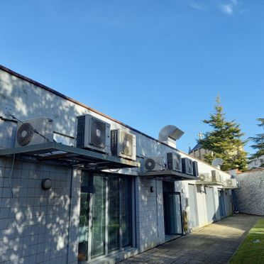 Un edificio con muchos aparatos de aire acondicionado en el lateral.