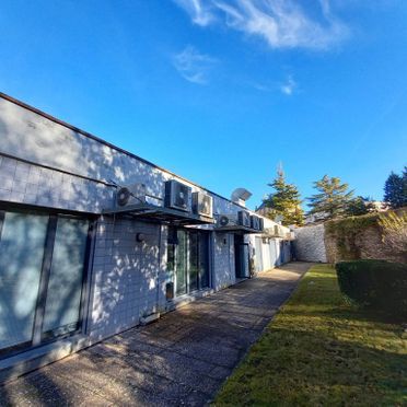 Un edificio grande con muchas ventanas y aparatos de aire acondicionado en los laterales.