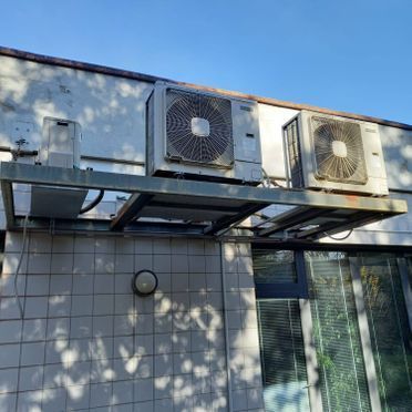 Dos acondicionadores de aire están montados en el lateral de un edificio.