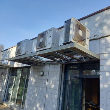 Un edificio con muchos aparatos de aire acondicionado en el lateral.