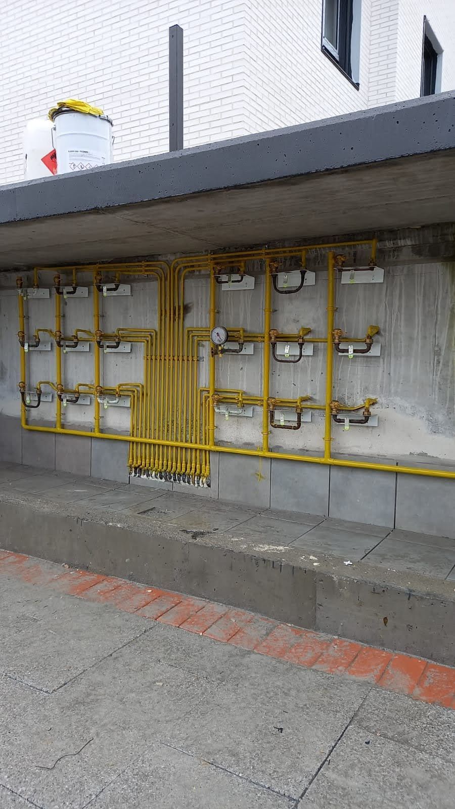 Una pared con un montón de tubos amarillos sobre ella.