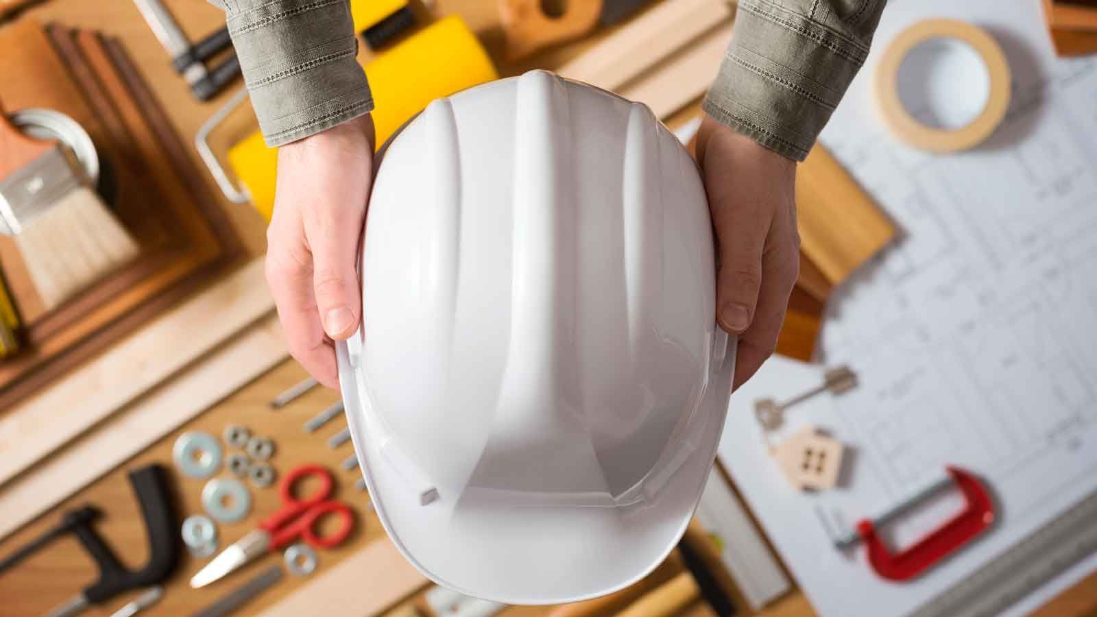 Una persona sostiene un casco blanco en sus manos.