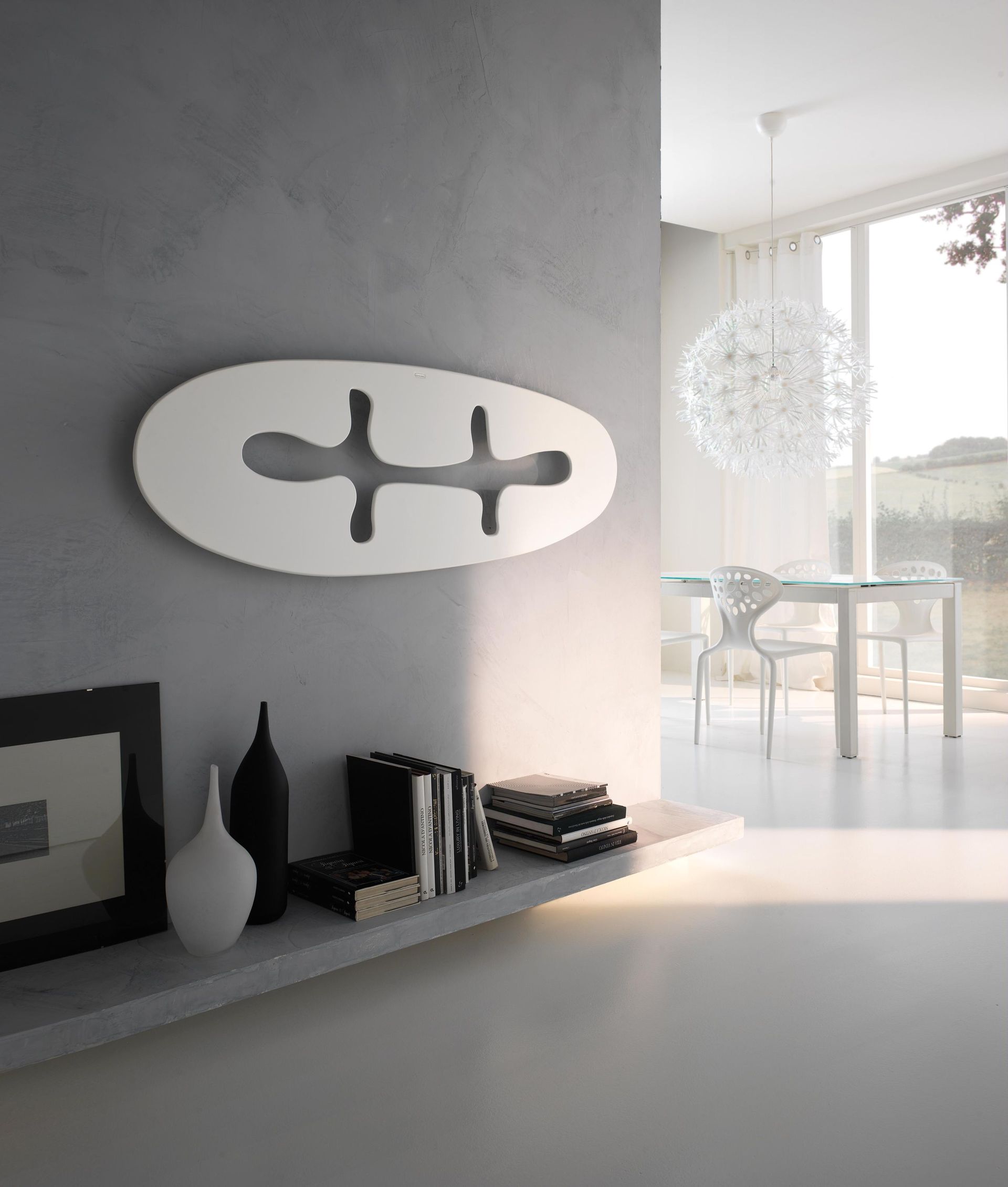 Una sala de estar con un estante con jarrones y libros.