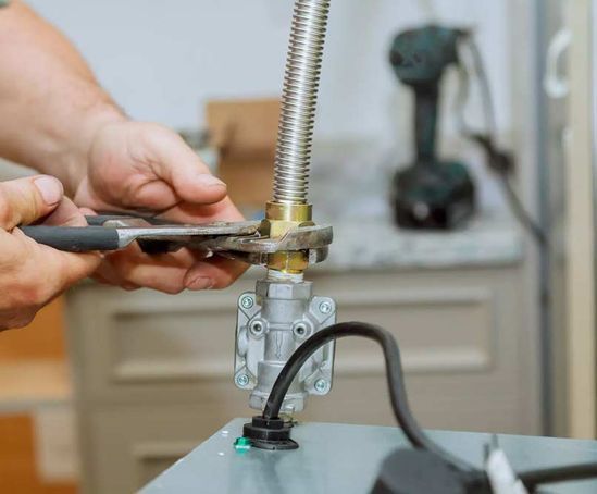Un hombre está arreglando un grifo con un par de alicates.