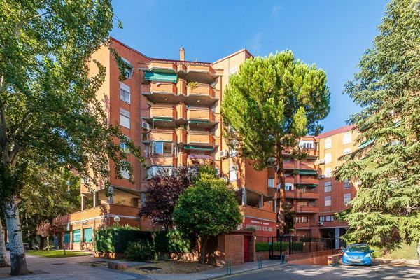 Una habitación vacía con suelos de madera y paredes blancas.