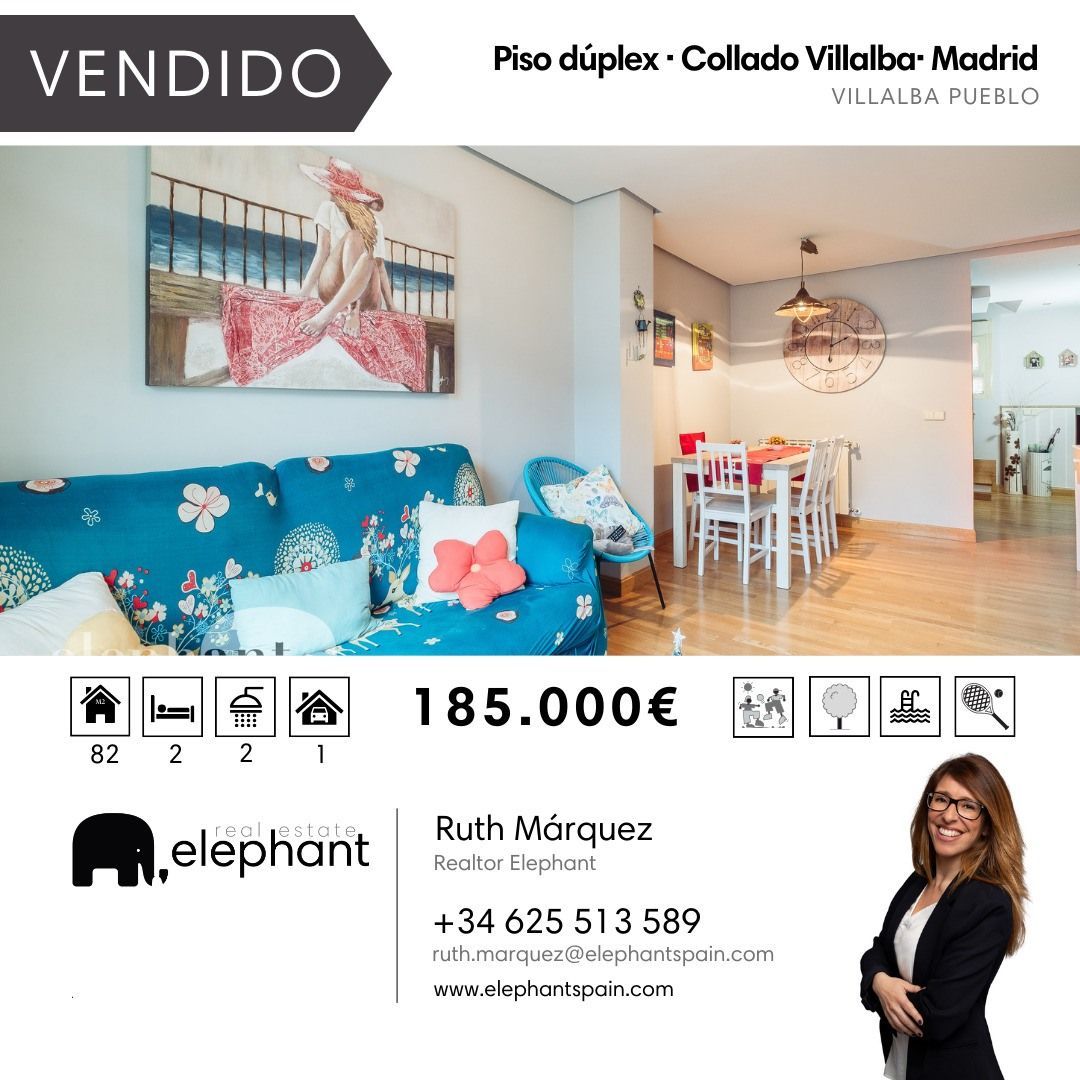 Una mujer está parada junto a un sofá azul en una sala de estar.